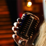 Jeune femme chantant dans un micro rétro